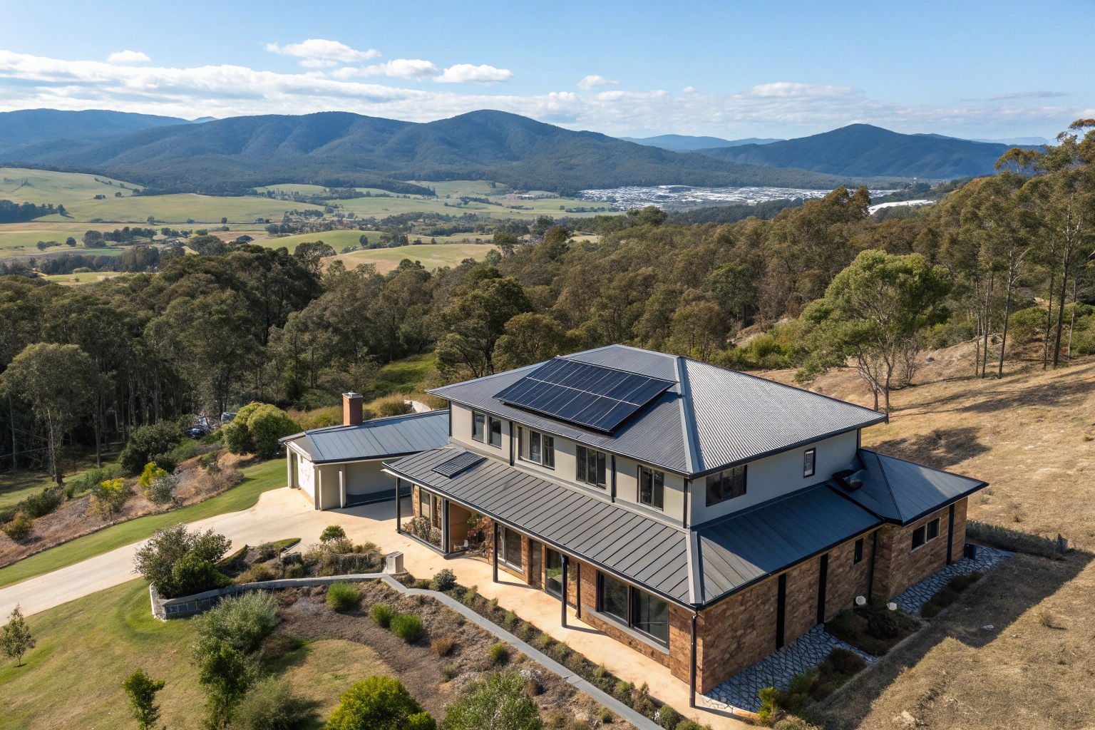 Modern Lenah Valley home with solar panels on sloped roof overlooking mountain ranges and valley landscape